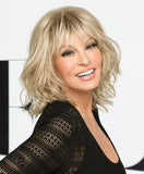 Raquel Welch Stop Traffic  Texture and movement are the inspiration for this blunt, to-the-shoulder bob. A soft, razor cut fringe frames the eyes while tousled and loose curls are layered throughout for natural volume and an unconstructed look. The Sheer Indulgence™ monofilament crown provides a natural contour.Sheer Indulgence™ Monofilament Crown Memory Cap® III Base Vibralite® Synthetic Hair